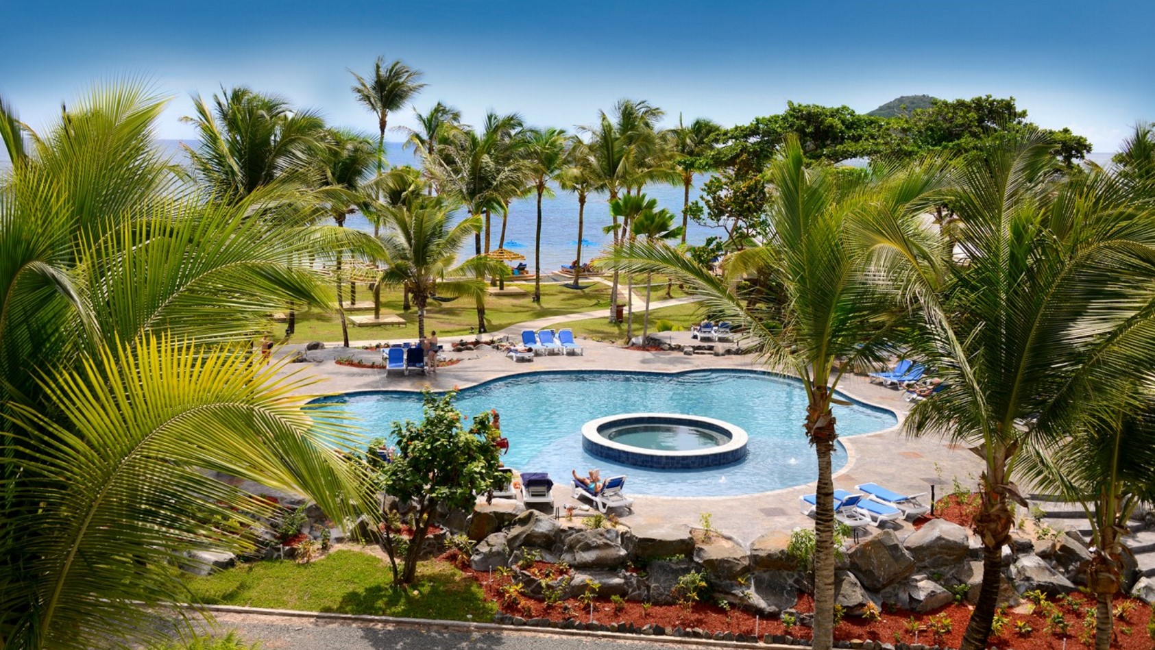 Coconut Bay in St. Lucia view of the pool with the ocean and sky in the background.