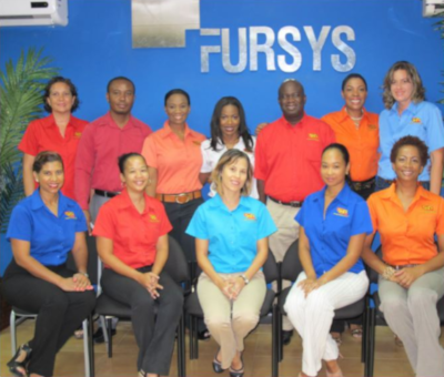 A group of employees in two rows for a photo in front of the name FURSYS.