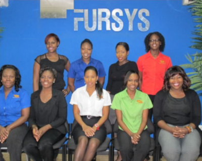 A group of employees in two rows for a photo in front of the name FURSYS.