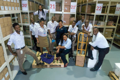 Medical Disposables & Supplies Limited warehouse with employees in uniform posing for a group photo.