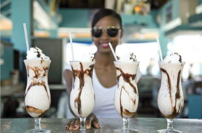 Wyndham Reef Resort, a woman sits with 4 milk shakes in front of her.