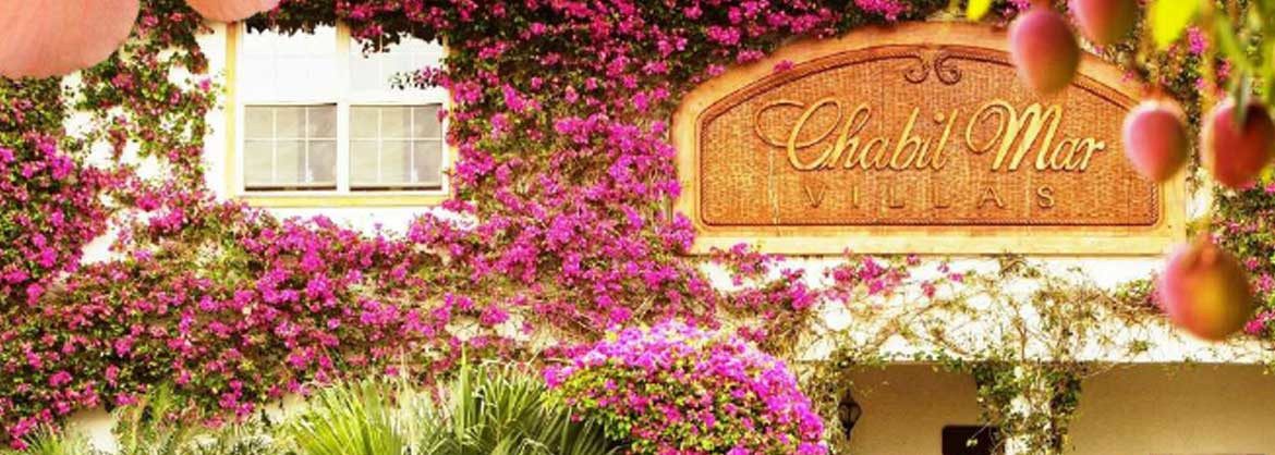 Chabil Mar Resort sign on their building with flowers and vines.