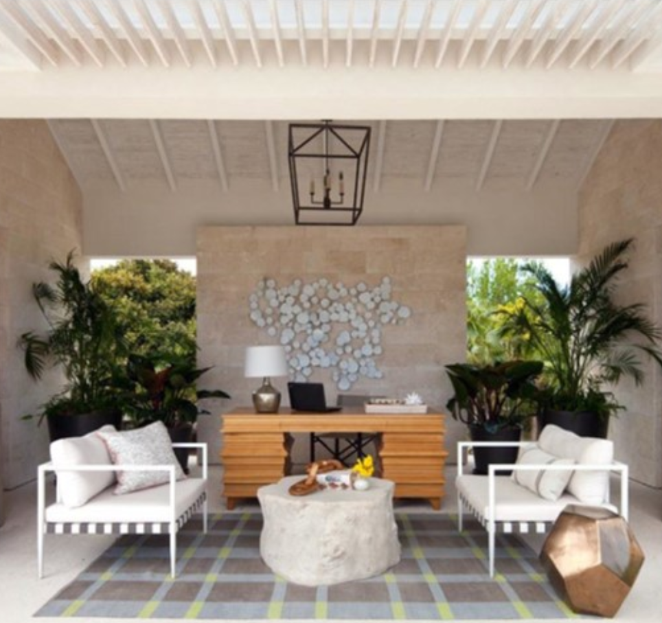 Living space showing a wood desk in the background with a stone table and two love seats in front. Project by Projetech Construction Management and Services.