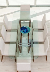 High quality Norstar Group example home showing white chairs around a clear glass table in a well lit room.