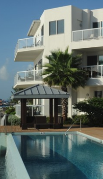 Arch and Godfrey. A multi story residential building with a pool in the foreground.