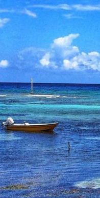 Ministry of District Administration, Tourism and Transport. A small boat with a single engine on the blue waters of the Caribbean.