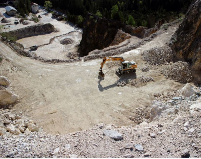 Lydford Mining. A long armed mobile excavator working on the upper steppe of an excavation site.