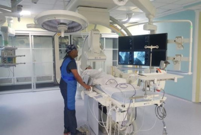 Medical Pavilion. A technician stands with an apron at equipment looking at monitors.