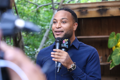 Miles Mercera, President of Curacao Hospitality and Tourism Association, speaks to a camera with two microphones in his hand.