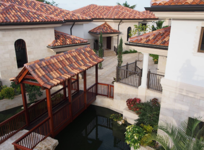 Flowers Group, view of tile roofed buildings and a covered walkway over a pond.