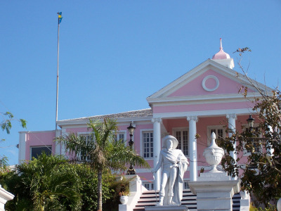 Nassau, Paradise Island. Nassau government building with a flag flying and statue out front.