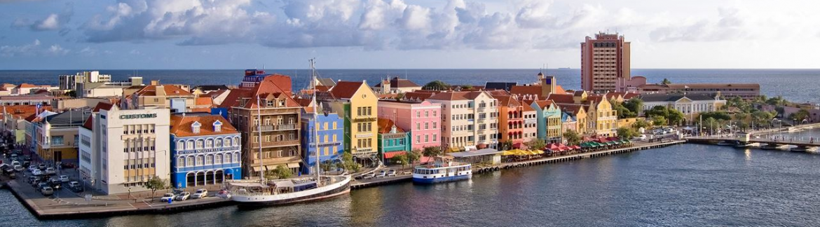 A view of colorful Caribbean buildings along the water.