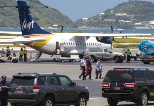 The British Virgin Islands Airports Authority. A plane on a runway with people and cars around.