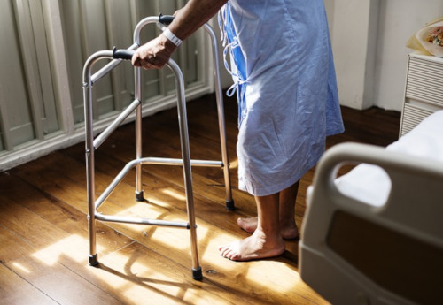 Victoria Hospital St. Lucia. Stock photo of the lower half of a patient using a walker next to their bed.