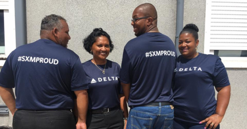 SXM Airport employees posing for a photo showing off #SXMPROUD Delta t-shirts.