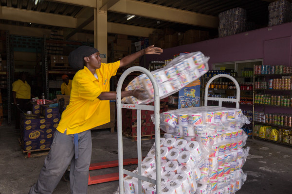 M.S. Osborne Ltd. employee loading a cart with toilet paper packages.