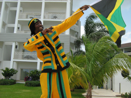 Jamaica Stock Exchange; A man posing holding the Jamaica flag.