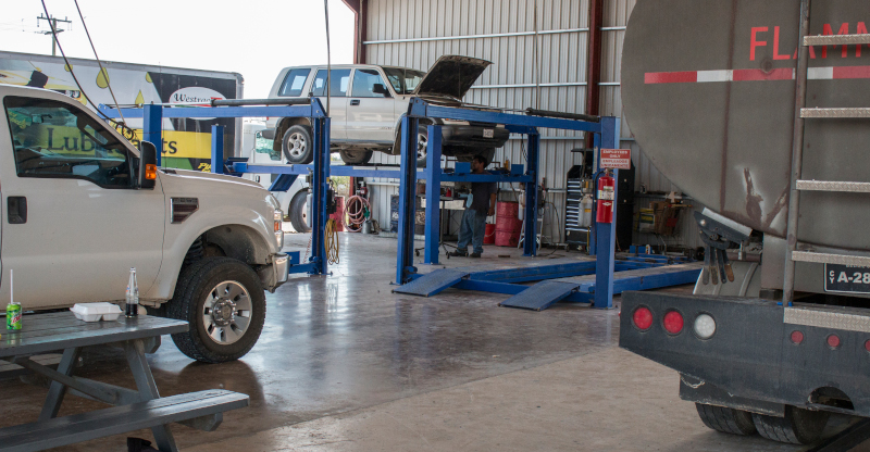 Westrac Limited Belize, view of a few vehicles in the repair shop, one on a lift.