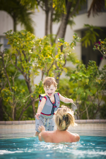 Carlisle Bay Resort Antigua child jumping into arms of parent in a pool.