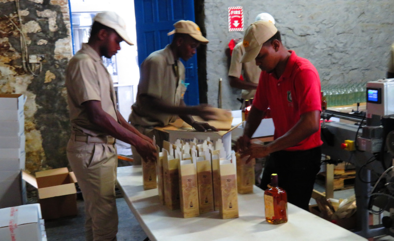 St. Vincent Distillers Limited employees packaging bottle of alcohol.