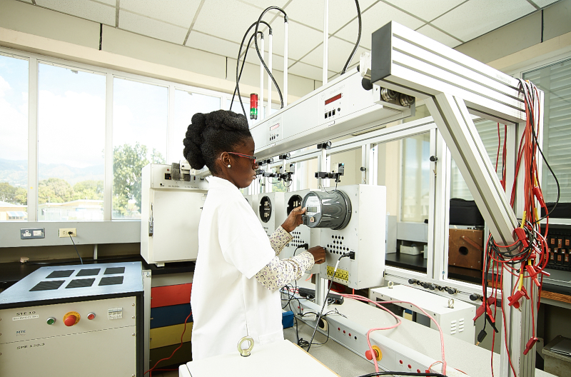 Bureau of Standards Jamaica BSJ; A woman using equipment in a lab like environment.